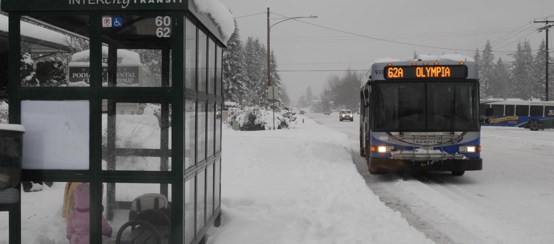 A bus in the snow stopping for passengers