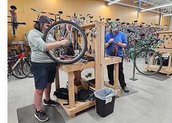 Two people working on bikes at bike shop